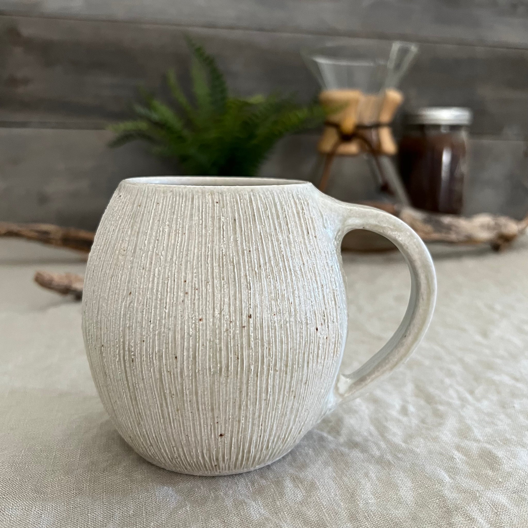 Handmade stoneware pottery. White textured globe coffee mug.