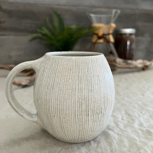 Handmade stoneware pottery. White textured globe coffee mug.