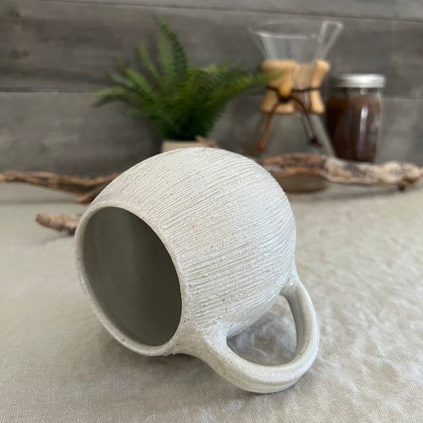 Handmade stoneware pottery. White textured globe coffee mug.