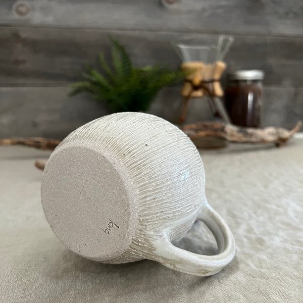 Handmade stoneware pottery. White textured globe coffee mug.