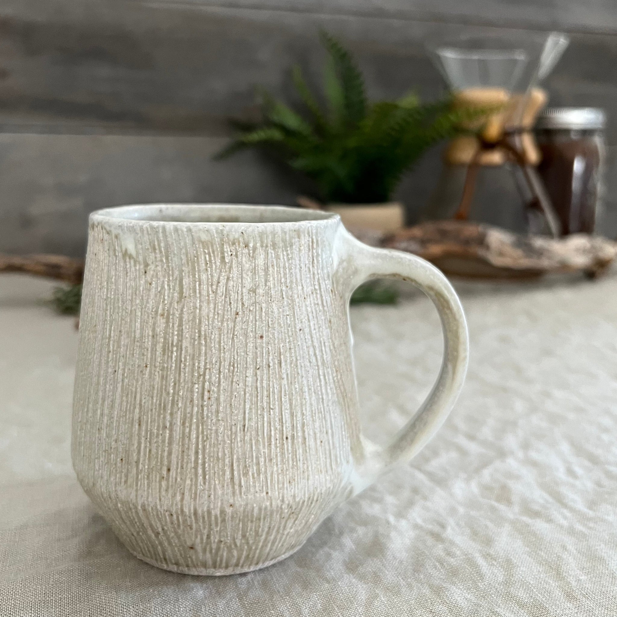 Handmade stoneware pottery. White textured coffee mug.