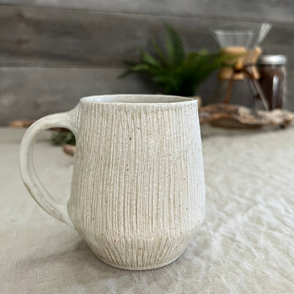 Handmade stoneware pottery. White textured coffee mug.