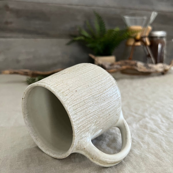 Handmade stoneware pottery. White textured coffee mug.