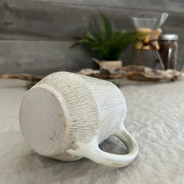 Handmade stoneware pottery. White textured coffee mug.