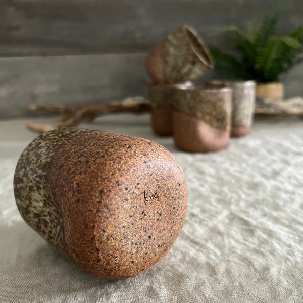 Handmade stoneware pottery. Dark speckled squish cup.