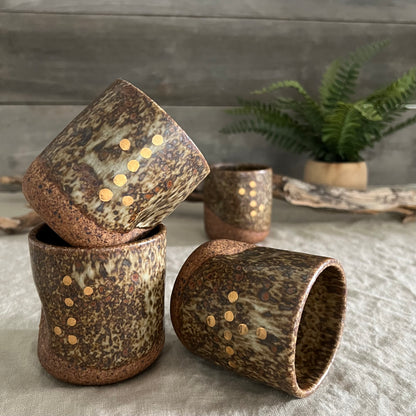 Handmade stoneware pottery. Dark speckled squish cup with gold luster dot accents.