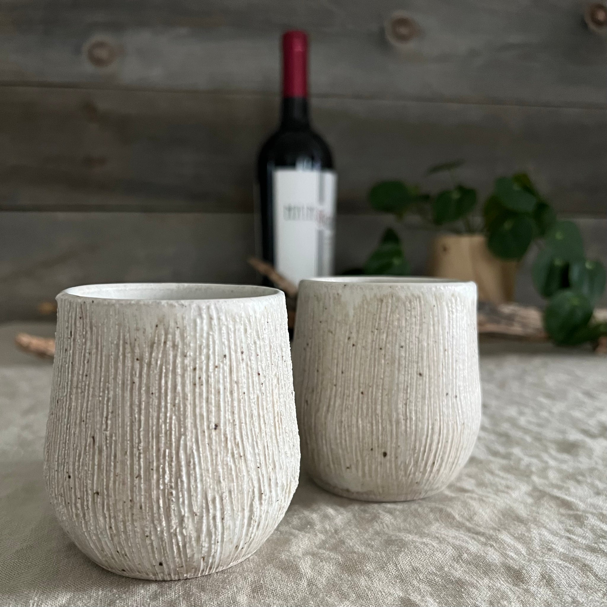 Handmade stoneware pottery. White textured stemless wine cup set.