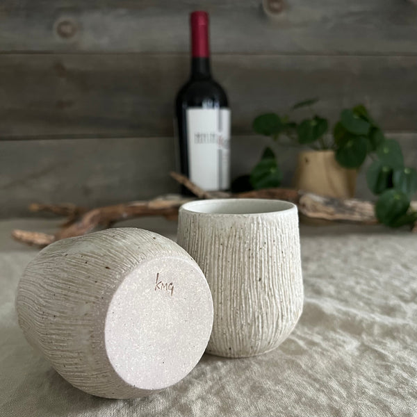 Handmade stoneware pottery. White textured stemless wine cup set.