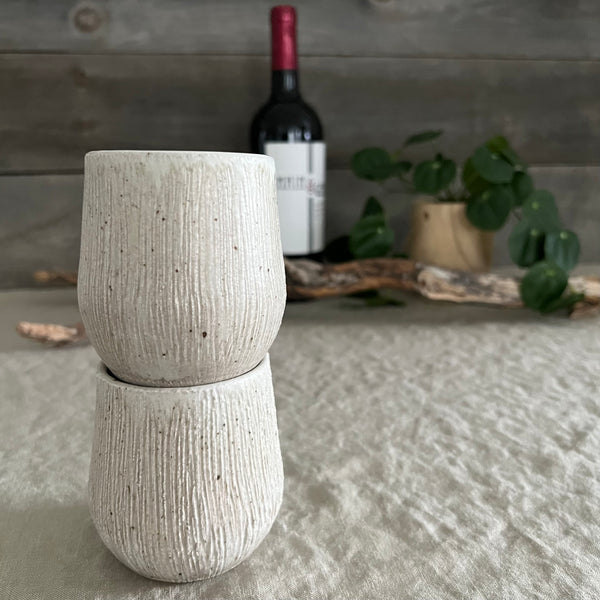 Handmade stoneware pottery. White textured stemless wine cup set.