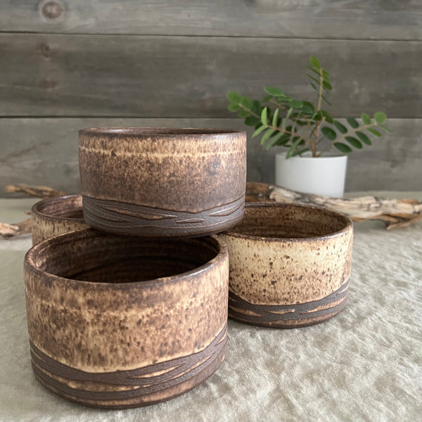 Handmade stoneware pottery. Rustic cereal bowls made of dark brown clay.