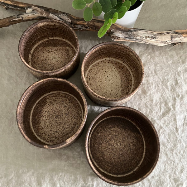 Handmade stoneware pottery. Rustic cereal bowls made of dark brown clay.