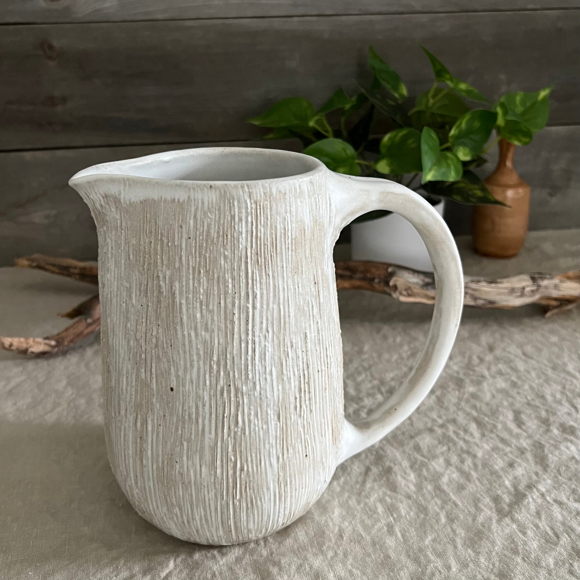 Handmade stoneware pottery. White textured pitcher.