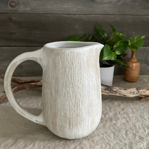 Handmade stoneware pottery. White textured pitcher.