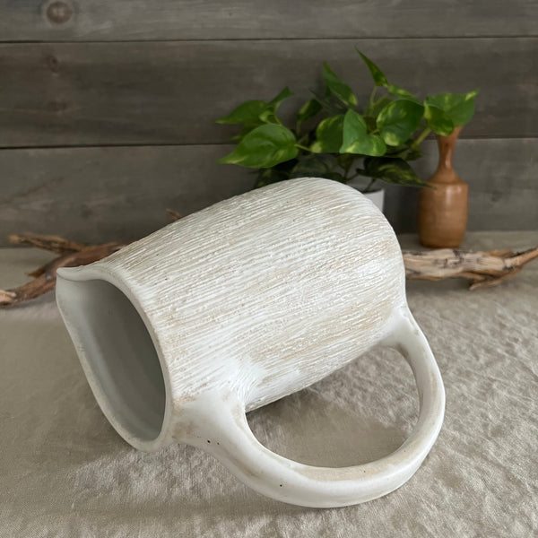 Handmade stoneware pottery. White textured pitcher.