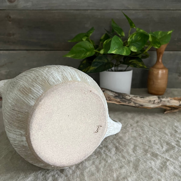 Handmade stoneware pottery. White textured pitcher.