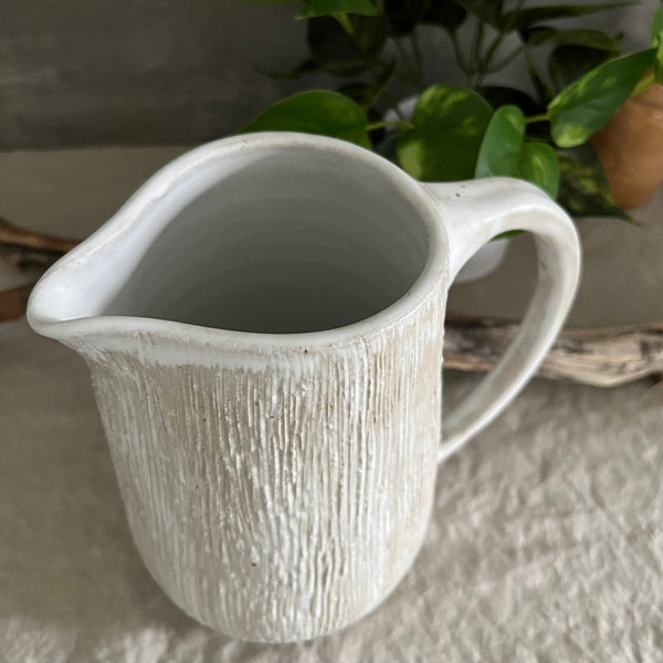 Handmade stoneware pottery. White textured pitcher.