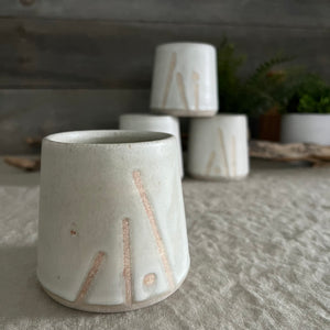 Handmade stoneware pottery. White cup with lines and dot accents.