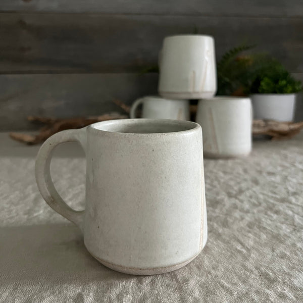 Handmade stoneware pottery. White coffee mug with lines and dot accents.