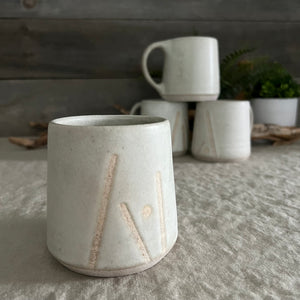 Handmade stoneware pottery. White coffee mug with lines and dot accents.