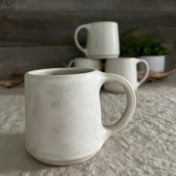 Handmade stoneware pottery. White coffee mug with lines and dot accents.