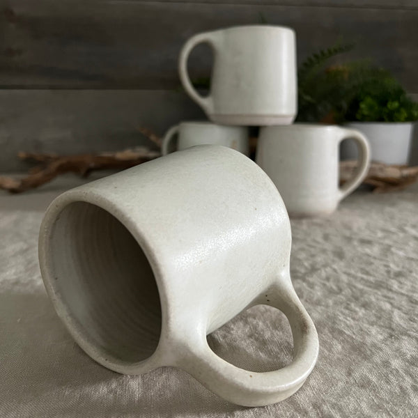 Handmade stoneware pottery. White coffee mug with lines and dot accents.