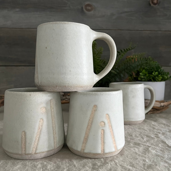 Handmade stoneware pottery. White coffee mug with lines and dot accents.